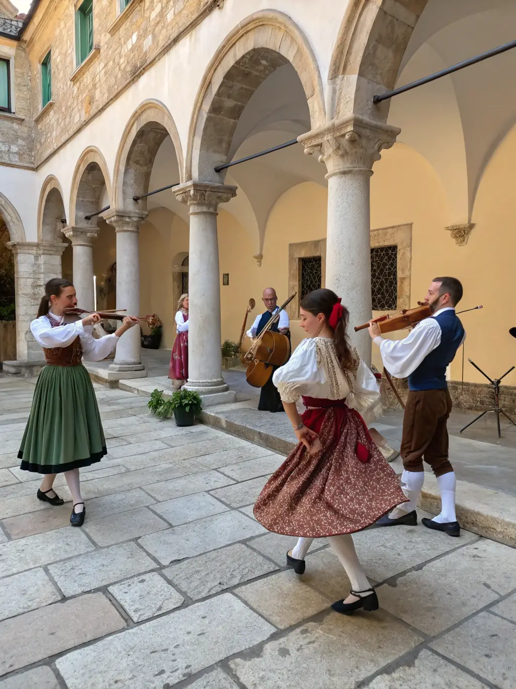 A vibrant image capturing a cultural event at Maison des Echevins, featuring traditional music and dance performances in the courtyard.